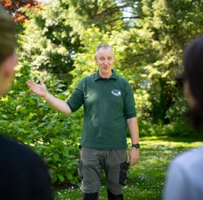 Guests enjoying a guided garden tour with lush greenery at the picturesque hotel grounds.
