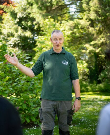 Guests enjoying a guided garden tour with lush greenery at the picturesque hotel grounds.