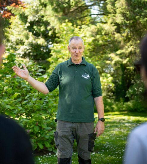 Guests enjoying a guided garden tour with lush greenery at the picturesque hotel grounds.
