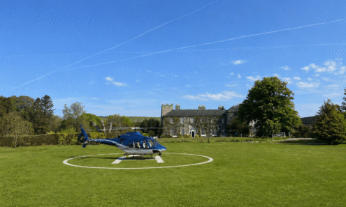 Luxurious hotel with helipad, surrounded by lush greenery and blue skies, offering exclusive travel convenience.